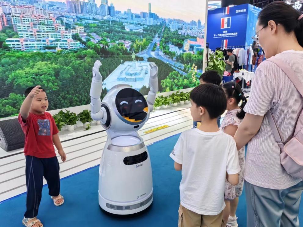 消博会现场，小朋友们正在与机器人互动。记者 杨迪摄